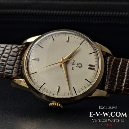 Omega Classic Gold Plaque watch with a vintage cream dial, gold hands, and a brown leather strap, a collector's piece from 1952.