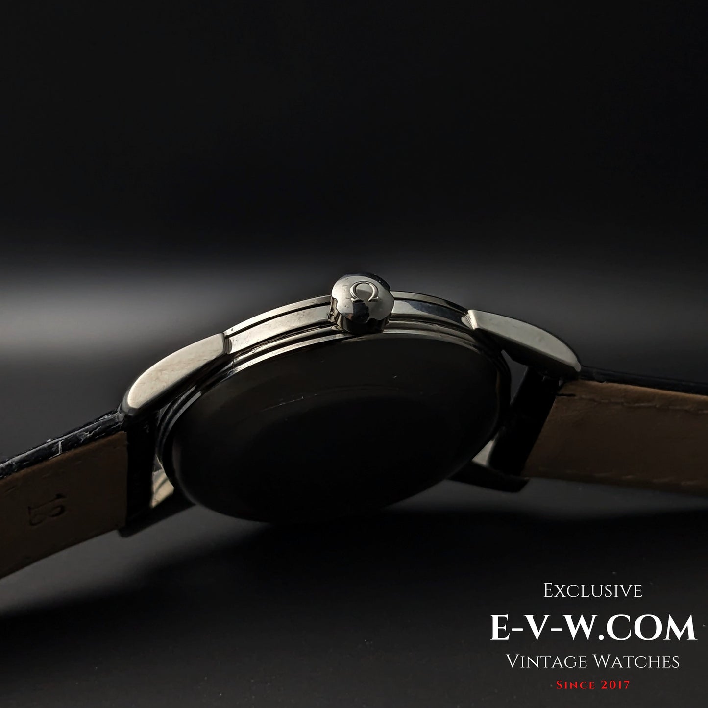 Crown-side profile of Vintage 1958 Omega Seamaster Automatic Watch with signed Omega crown and black leather strap.