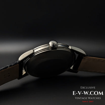 Crown-side profile of Vintage 1958 Omega Seamaster Automatic Watch with signed Omega crown and black leather strap.