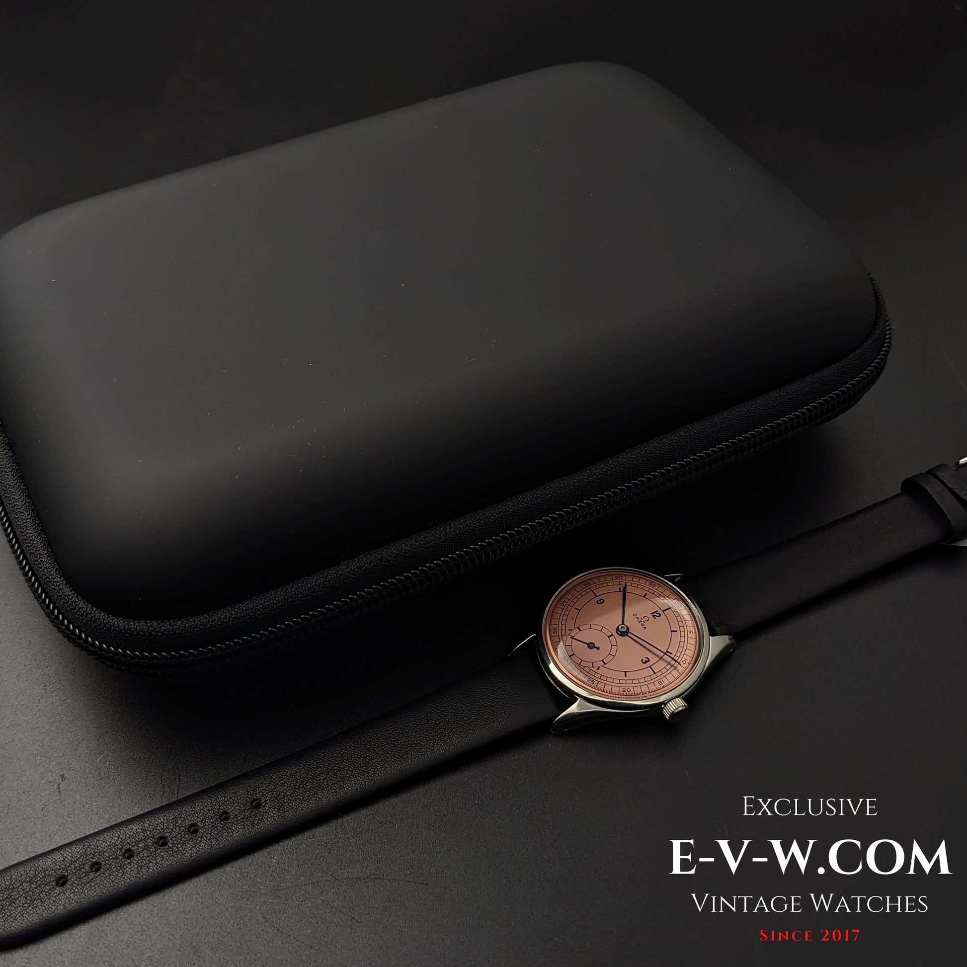 Omega Vintage 1952 Jumbo Ref. 2505 wristwatch placed next to a black protective travel case for secure storage.