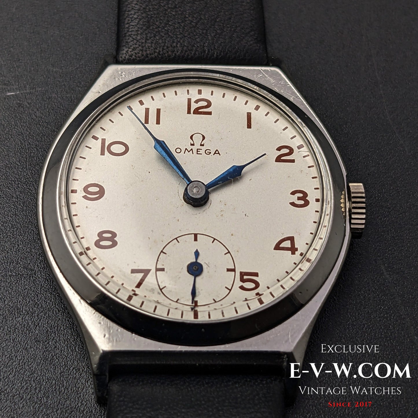 Detailed view of the Omega Art Deco wristwatch dial, highlighting the patina on the silver face, blue hands, and sub-seconds display.