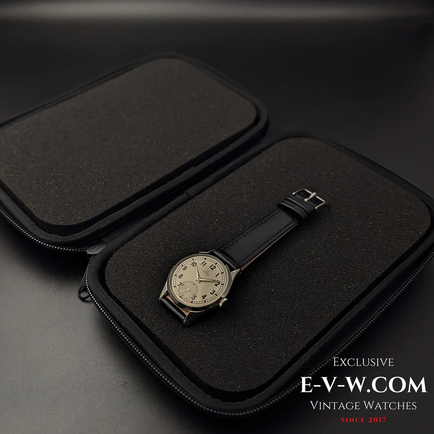 Omega FAB SUISSE Ref. 2750-6 vintage wristwatch inside an open black protective case. A 1954 Swiss-made timepiece with a silver dial.