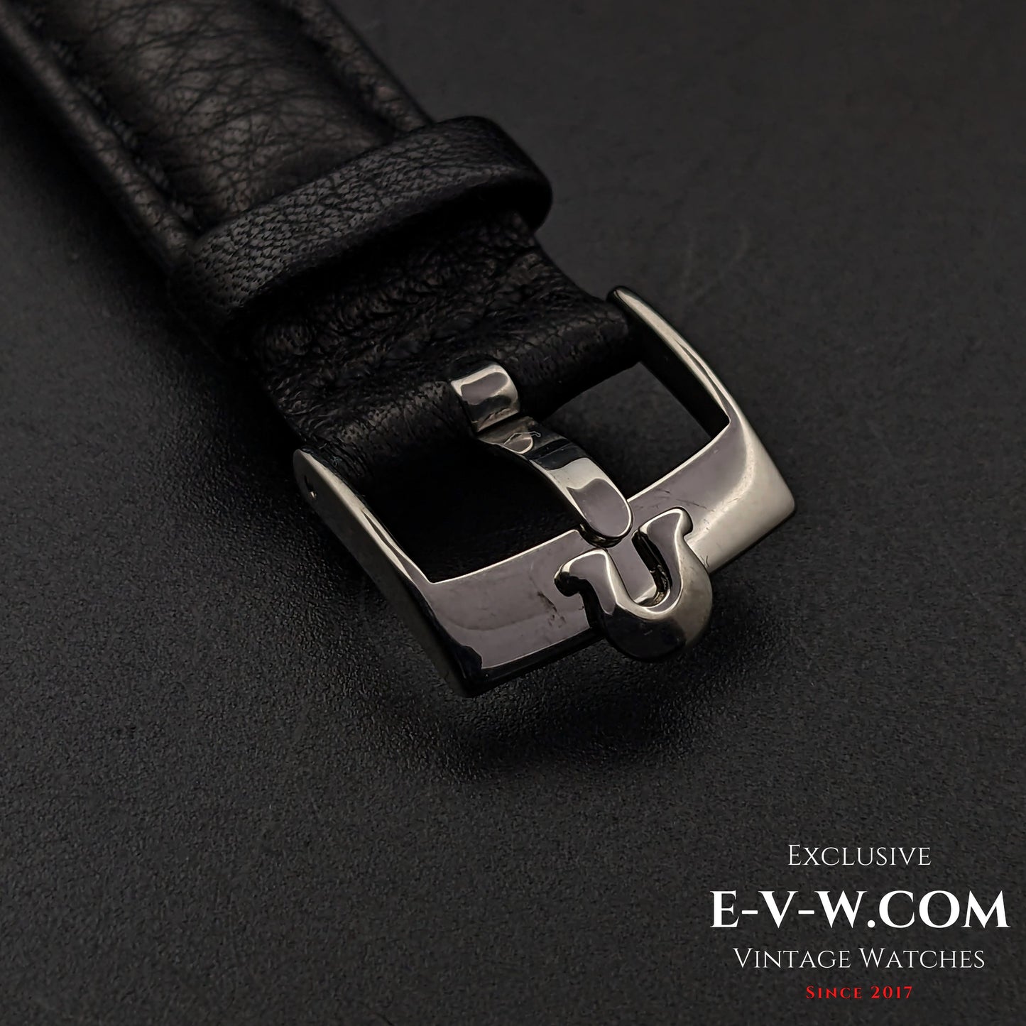 Close-up of the black leather strap and stainless steel buckle of the Omega Jumbo 38mm Ref. 2505 20, featuring a vintage Omega logo.