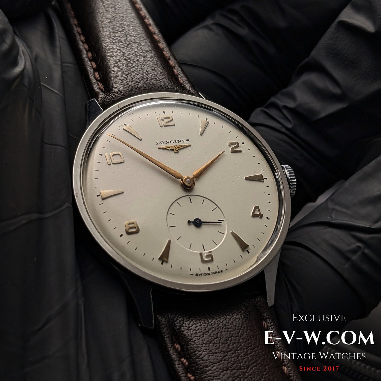 Close-up of 1955 Longines Jumbo Calatrava Ref 2849 watch with Cal. 1268Z, featuring a silver dial and gold-tone hands on brown leather strap.