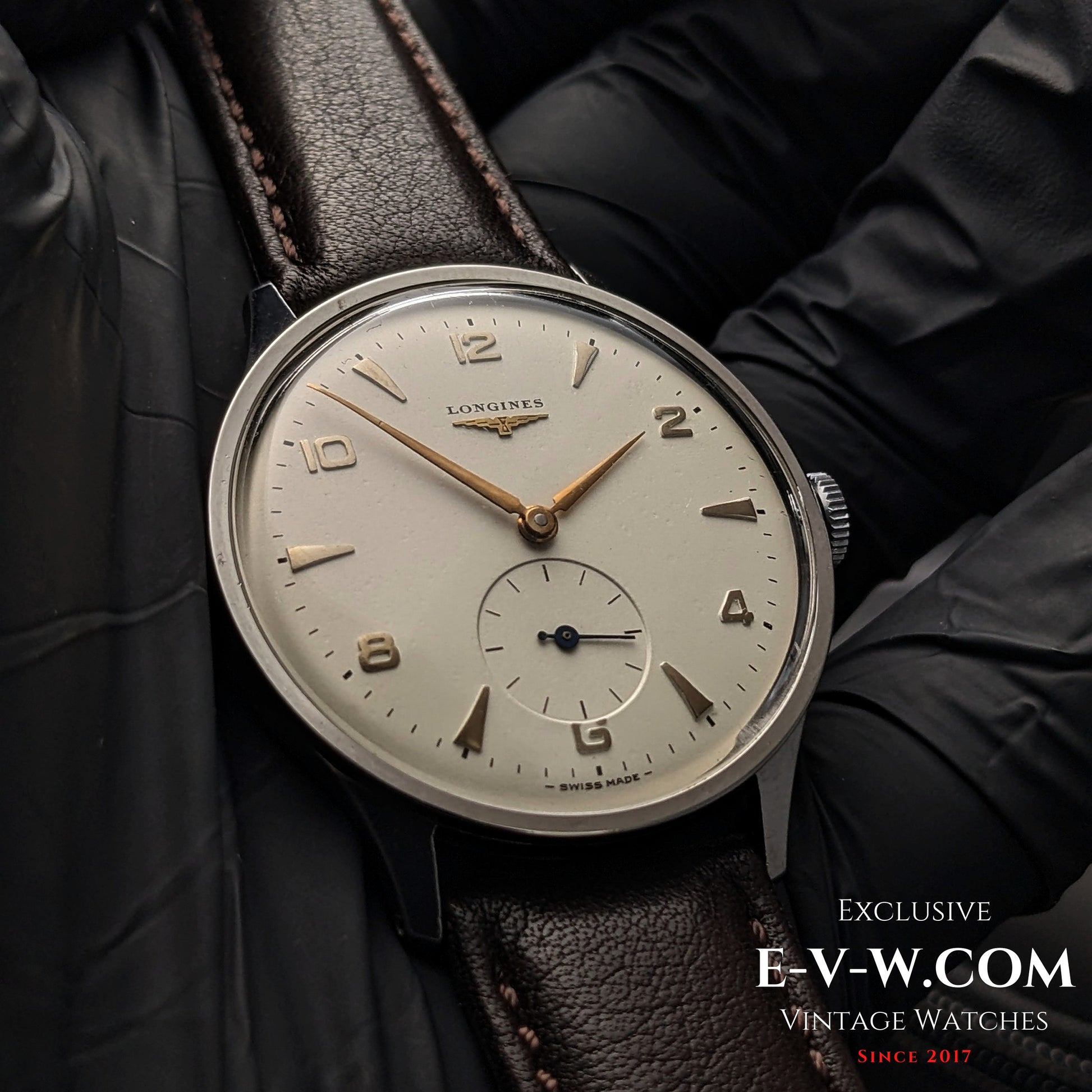 Close-up of 1955 Longines Jumbo Calatrava Ref 2849 watch with Cal. 1268Z, featuring a silver dial and gold-tone hands on brown leather strap.