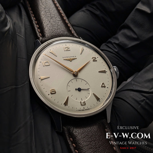 Close-up of 1955 Longines Jumbo Calatrava Ref 2849 watch with Cal. 1268Z, featuring a silver dial and gold-tone hands on brown leather strap.