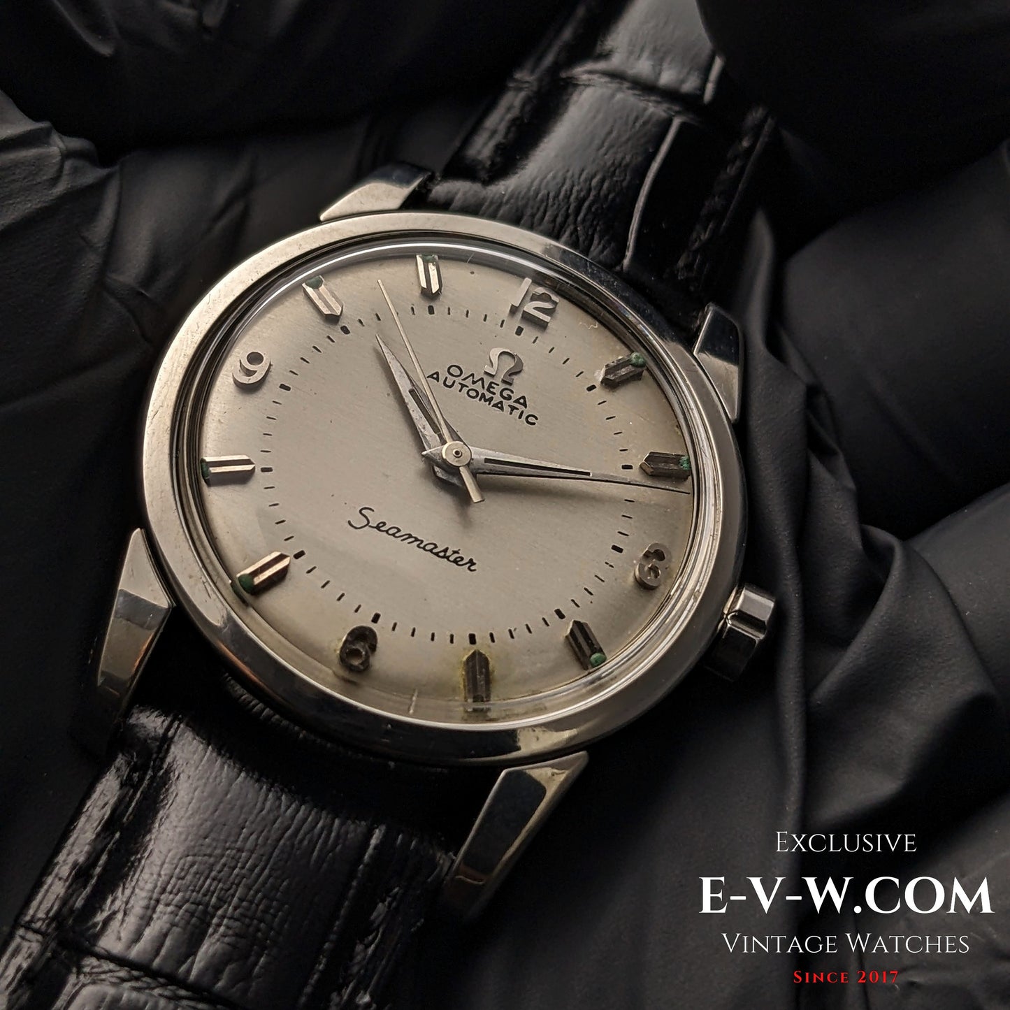 Vintage 1958 Omega Seamaster Automatic Watch with silver dial, Cal. 501 movement, and black leather strap, displayed on black gloves.