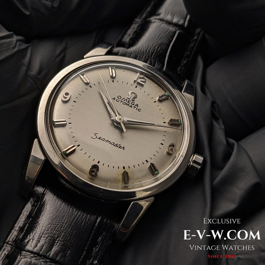 Vintage 1958 Omega Seamaster Automatic Watch with silver dial, Cal. 501 movement, and black leather strap, displayed on black gloves.