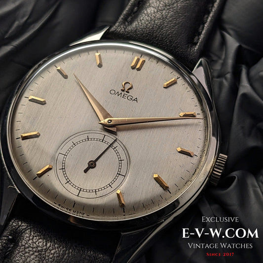 Vintage 1950 Omega Jumbo 38mm Ref. 2505 20 wristwatch with silver dial, gold indices, and sub-seconds. Classic design with a black leather strap.