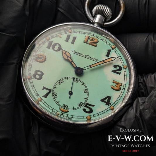 Jaeger-LeCoultre WWII Military Watch Cal. 467 Vintage 1940 with luminous dial and bold Arabic numerals, displayed on black gloves.
