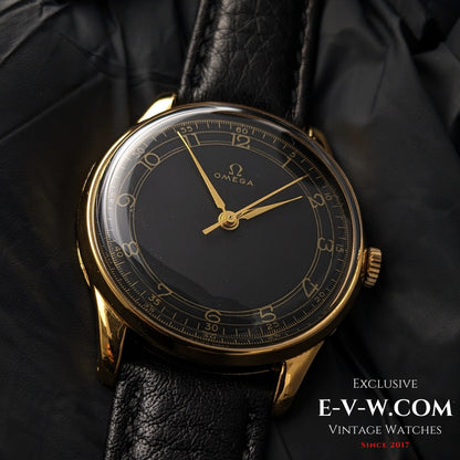 Vintage Omega WWII Gold Watch 1944 with black sector dial and gold-plated case, displayed on black leather strap for collectors.