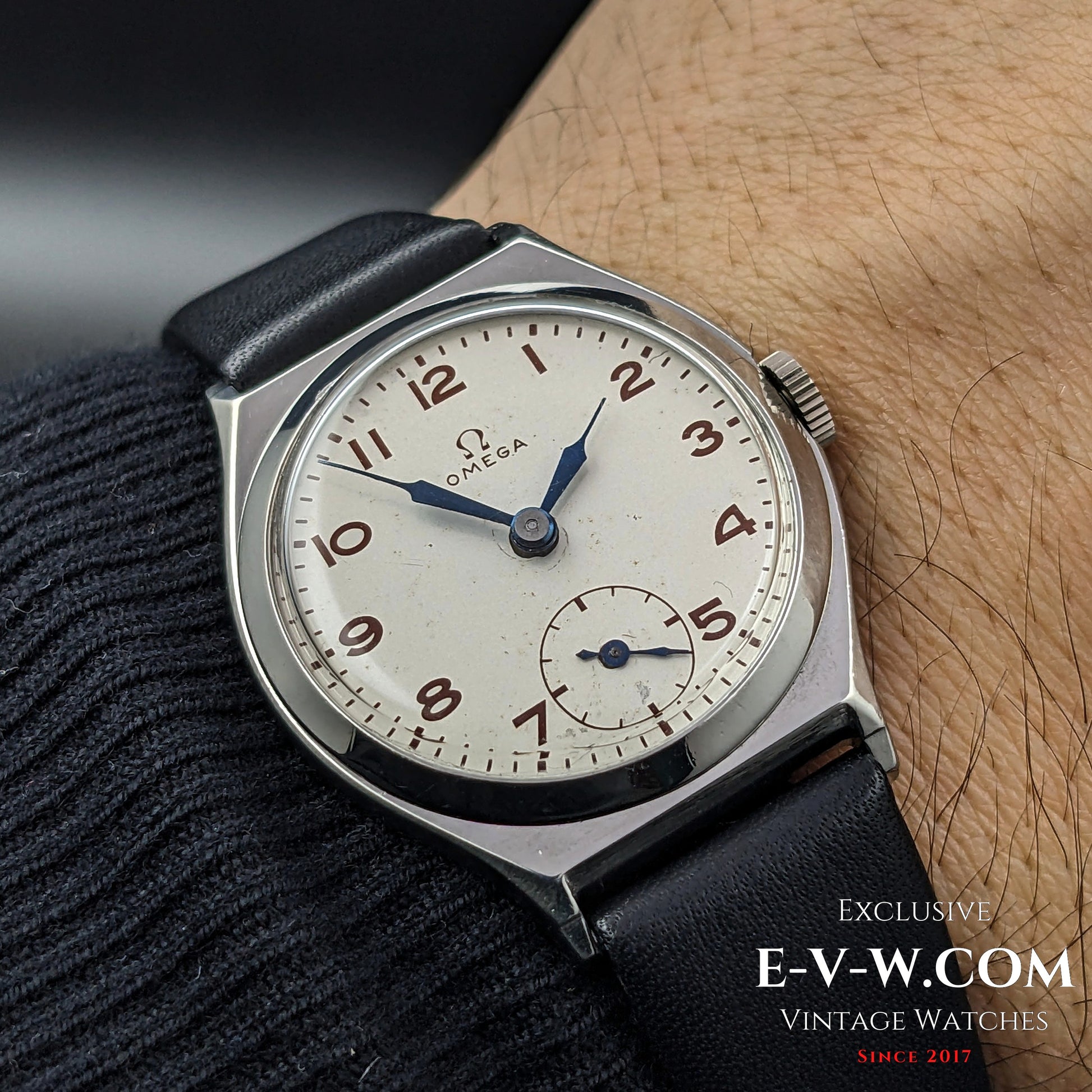 Antique Omega Art Deco wristwatch from 1935 worn on wrist, showcasing its classic design with a silver dial, blue hands, and sub-seconds display.