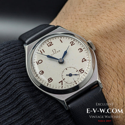 Antique Omega Art Deco wristwatch from 1935 worn on wrist, showcasing its classic design with a silver dial, blue hands, and sub-seconds display.