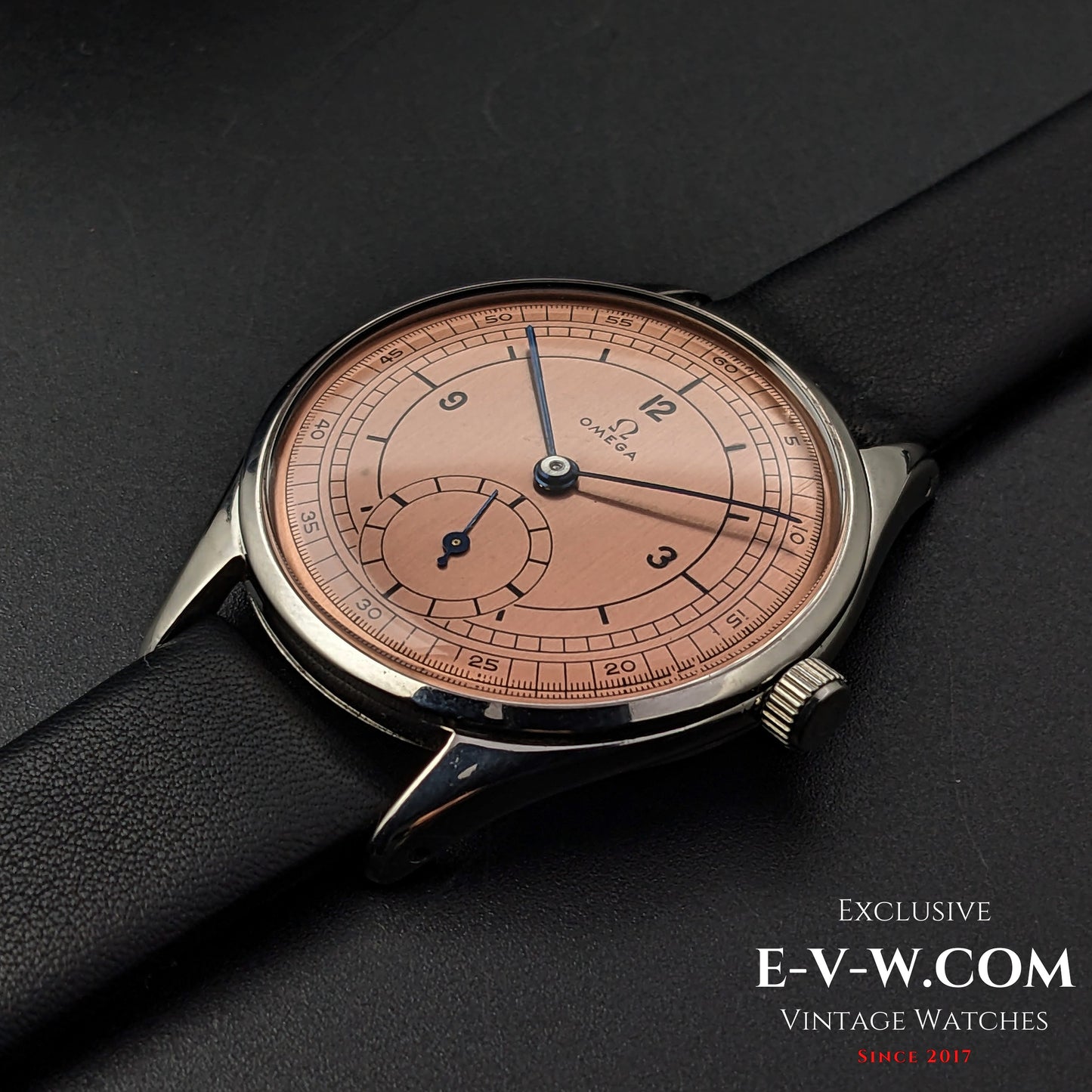 Close-up of Omega Vintage 1952 Jumbo Ref. 2505 wristwatch with salmon sector dial, black leather strap, and steel case.