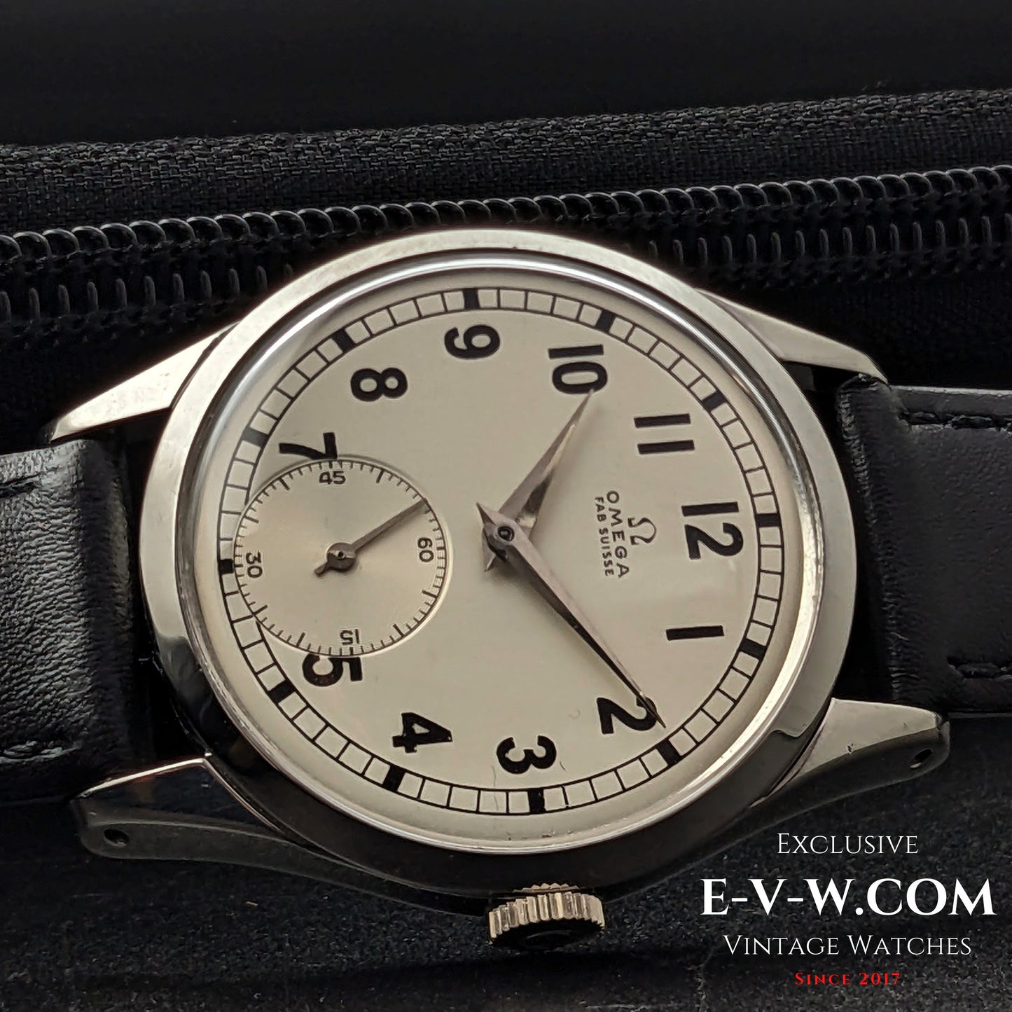 Close-up of the Omega FAB SUISSE Ref. 2750-6 vintage wristwatch in a black leather case. Features a silver dial with black numerals and a subdial.