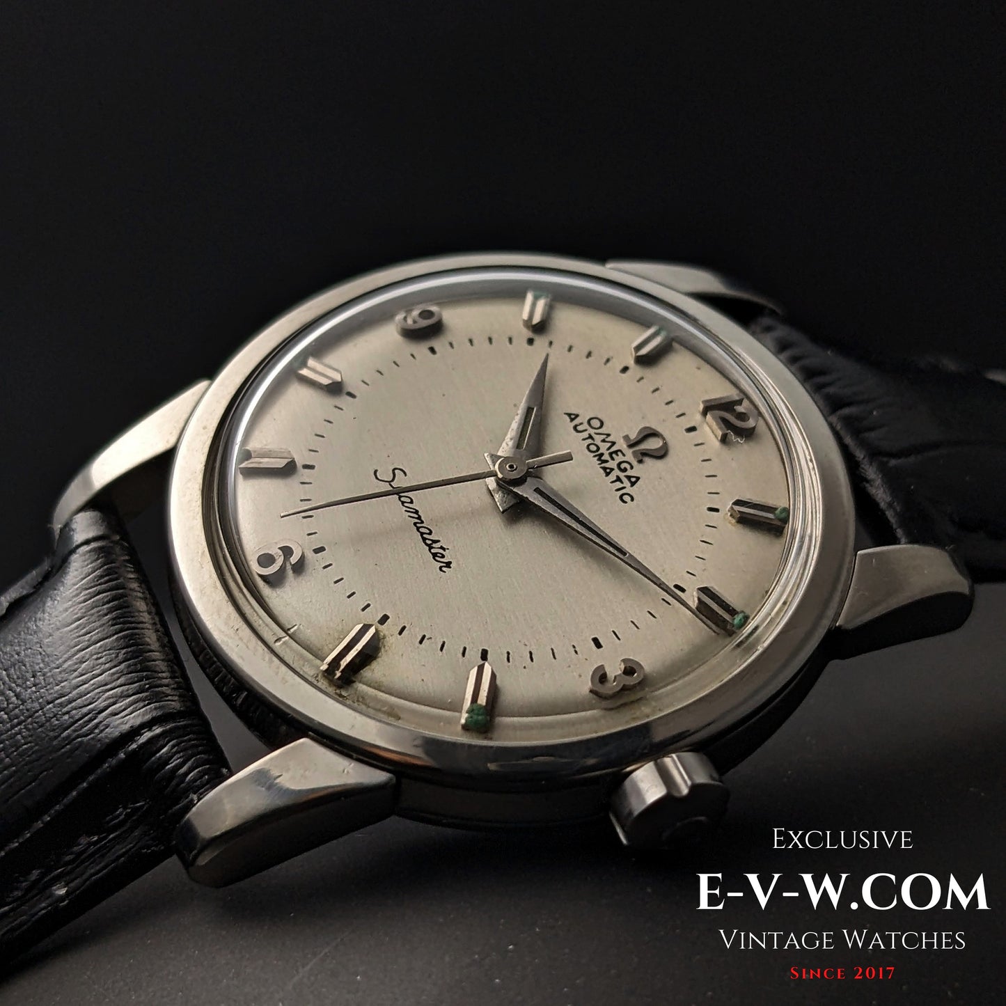 Angled view of Vintage 1958 Omega Seamaster Automatic Watch with domed crystal and silver-tone case on black leather strap.