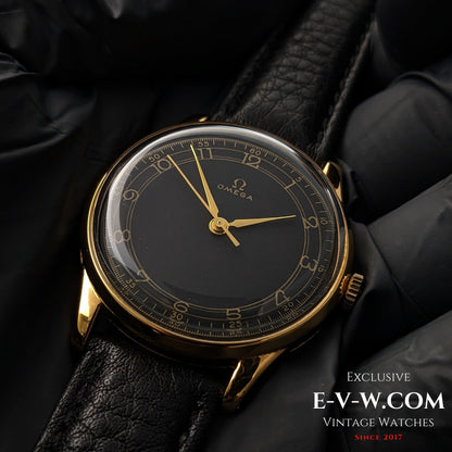 Vintage Omega WWII Gold Watch 1944 with black and gold sector dial, displayed on black leather strap for luxury timepiece collectors.