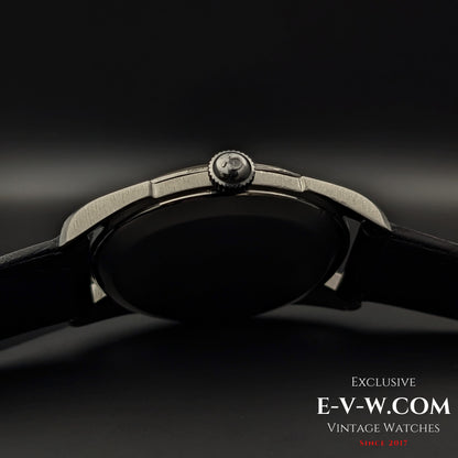 Side profile of Omega CK 2900 Vintage 1956 watch, highlighting the signed Omega crown and polished stainless steel case. A refined vintage watch.