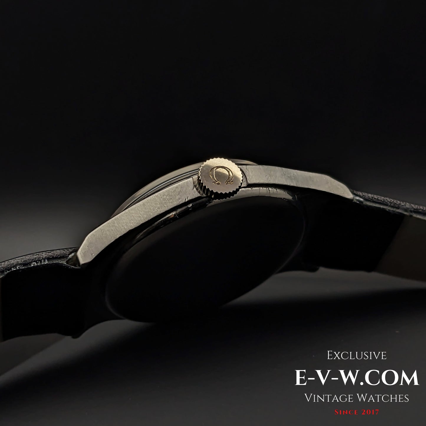 Close-up of the Omega wristwatch crown with logo engraving, showcasing the fine details of the 1935 vintage Art Deco timepiece in a steel case.