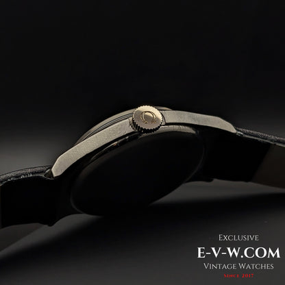 Close-up of the Omega wristwatch crown with logo engraving, showcasing the fine details of the 1935 vintage Art Deco timepiece in a steel case.