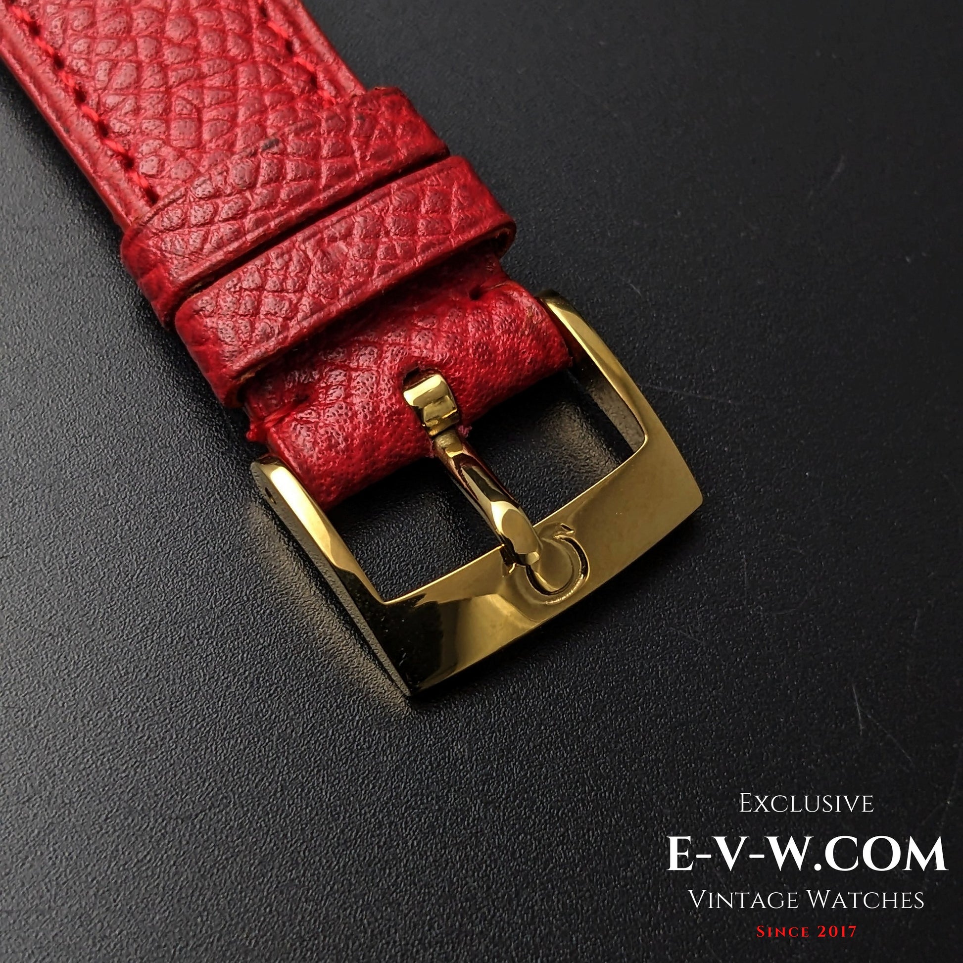 Gold-tone Omega buckle on textured red leather strap, part of the 1957 Omega vintage 24-hour dial watch collection.