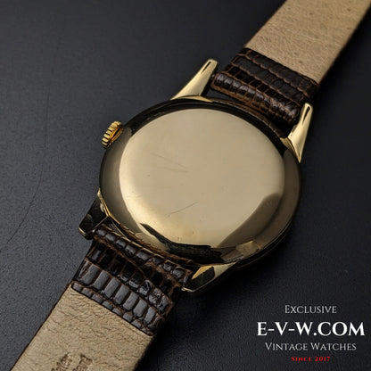 Back view of the Vintage Omega Classic Gold Plaque watch, showing its polished gold case and brown leather strap from 1952.