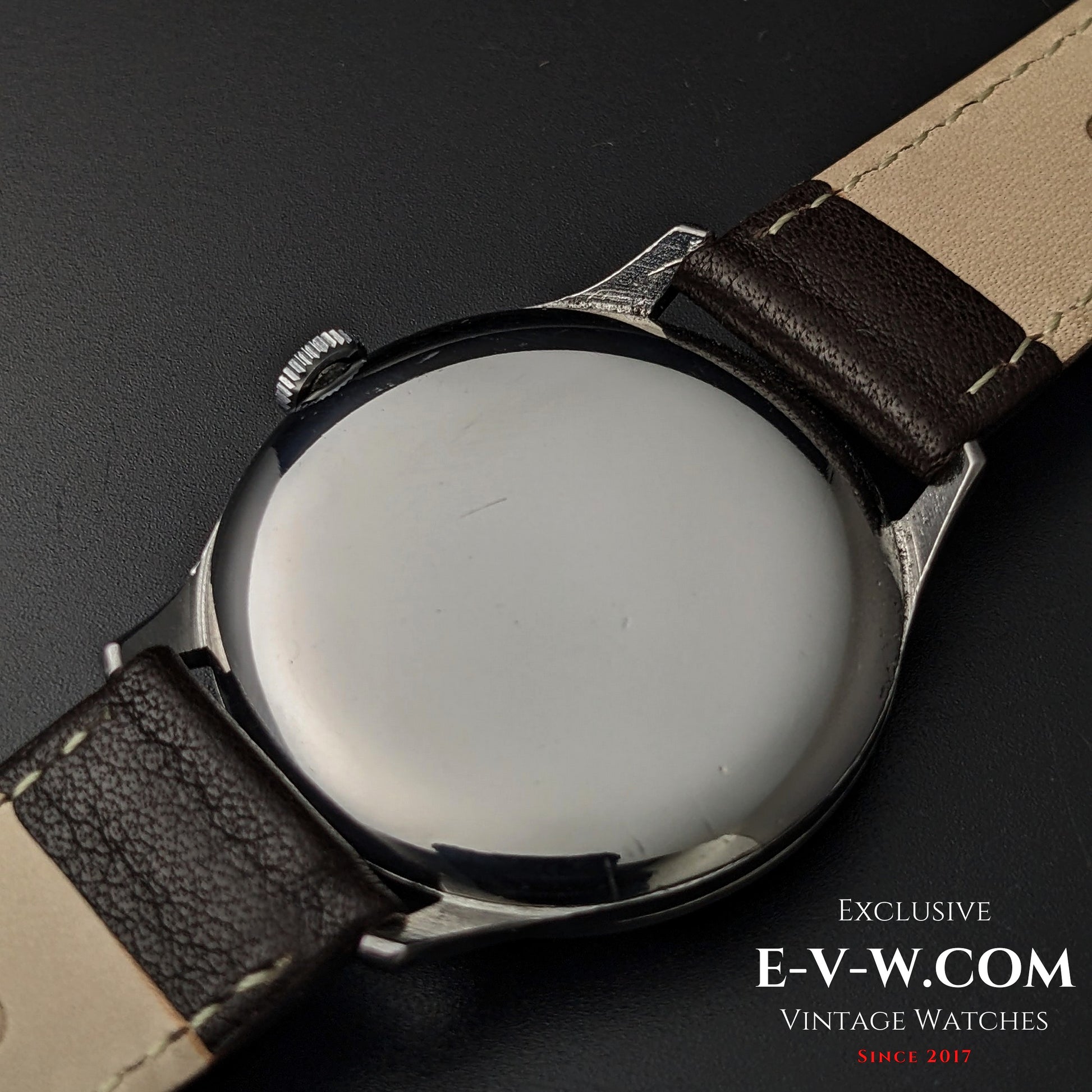 Back view of 1955 Longines Jumbo Calatrava Ref 2849 showing polished stainless steel case and brown leather strap.