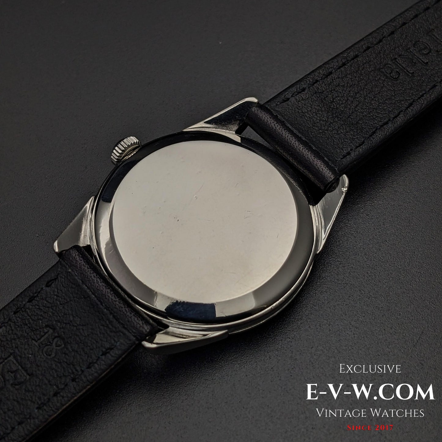 Back view of Omega CK 2900 Vintage 1956 watch, featuring a polished stainless steel case back and black leather strap. A timeless vintage piece.