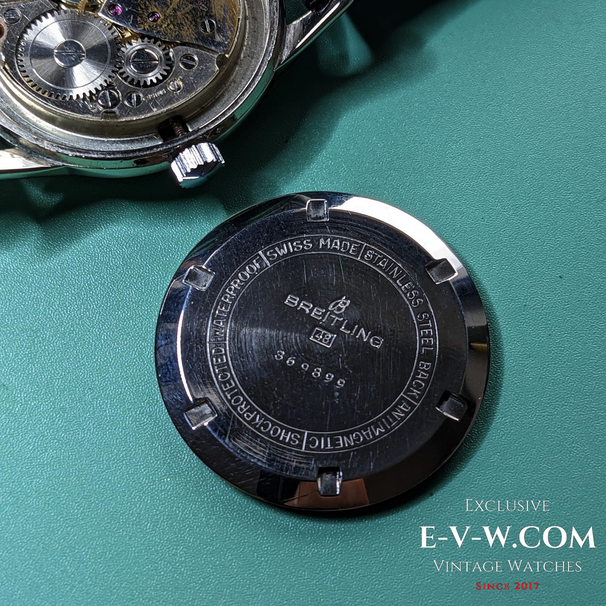 Back case of Vintage Breitling Geneve Cadette Watch 1960s engraved with branding and specifications like antimagnetic and shockproof features.