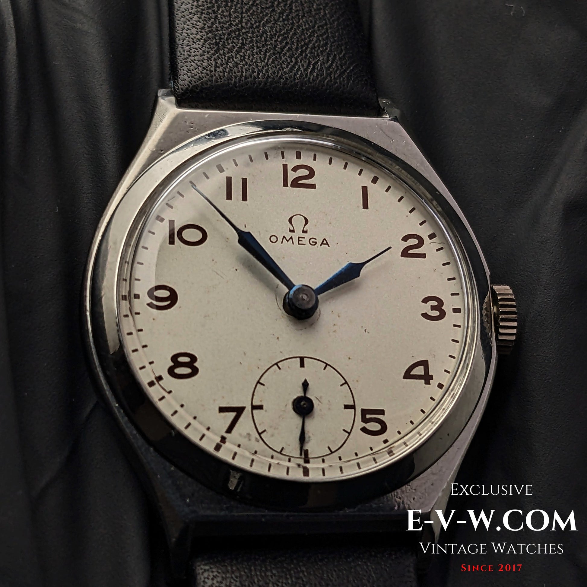 Close-up of the Omega Art Deco wristwatch dial, featuring a silver-tone face, blue hands, Arabic numerals, and a small seconds subdial.