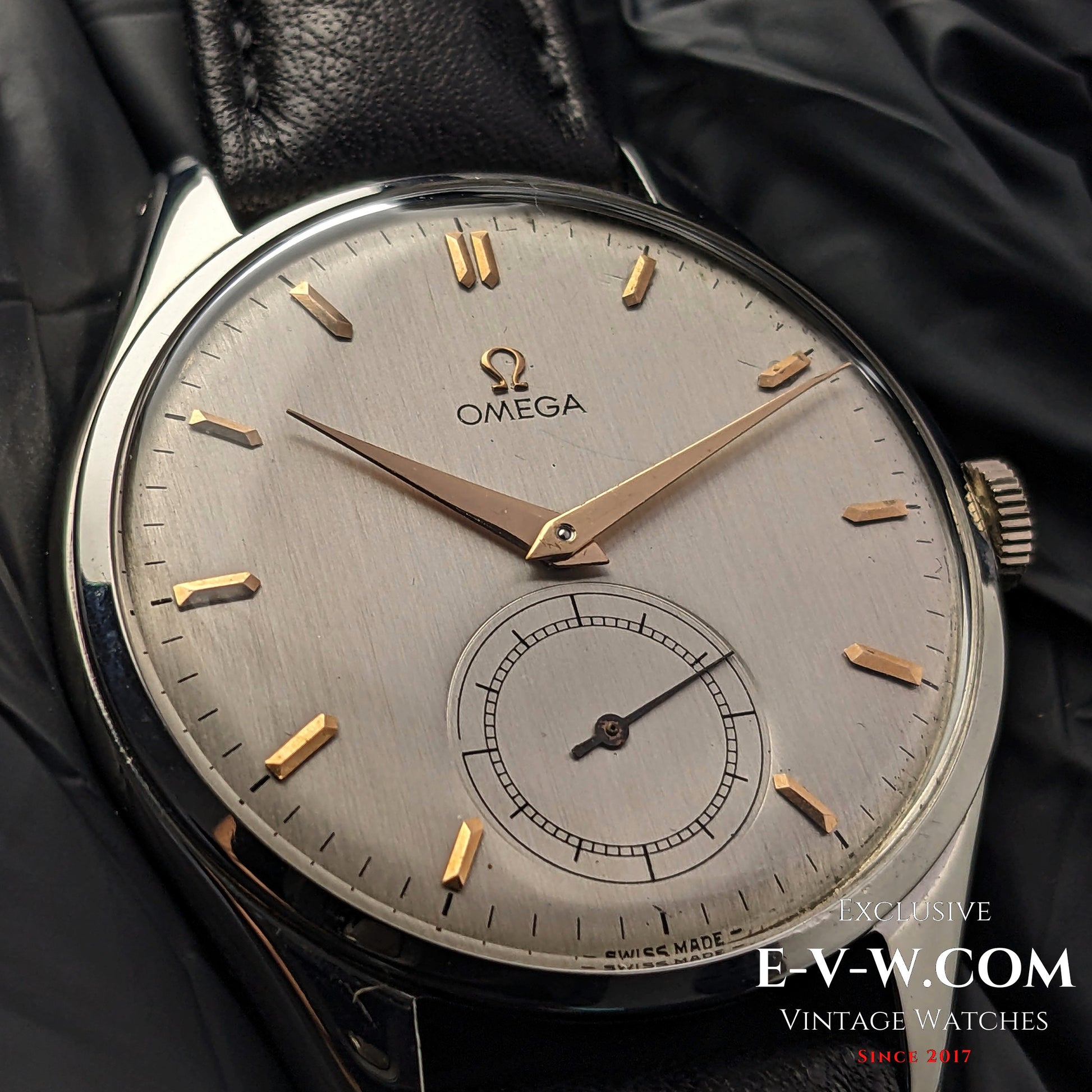 Macro shot of Omega Jumbo 38mm Ref. 2505 20 wristwatch, showcasing its brushed silver dial, gold indices, and sub-seconds complication.