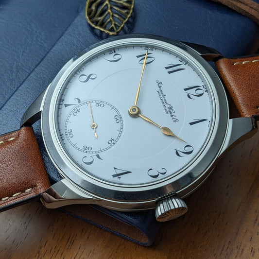 Vintage wristwatch with brown leather strap on a blue textured background