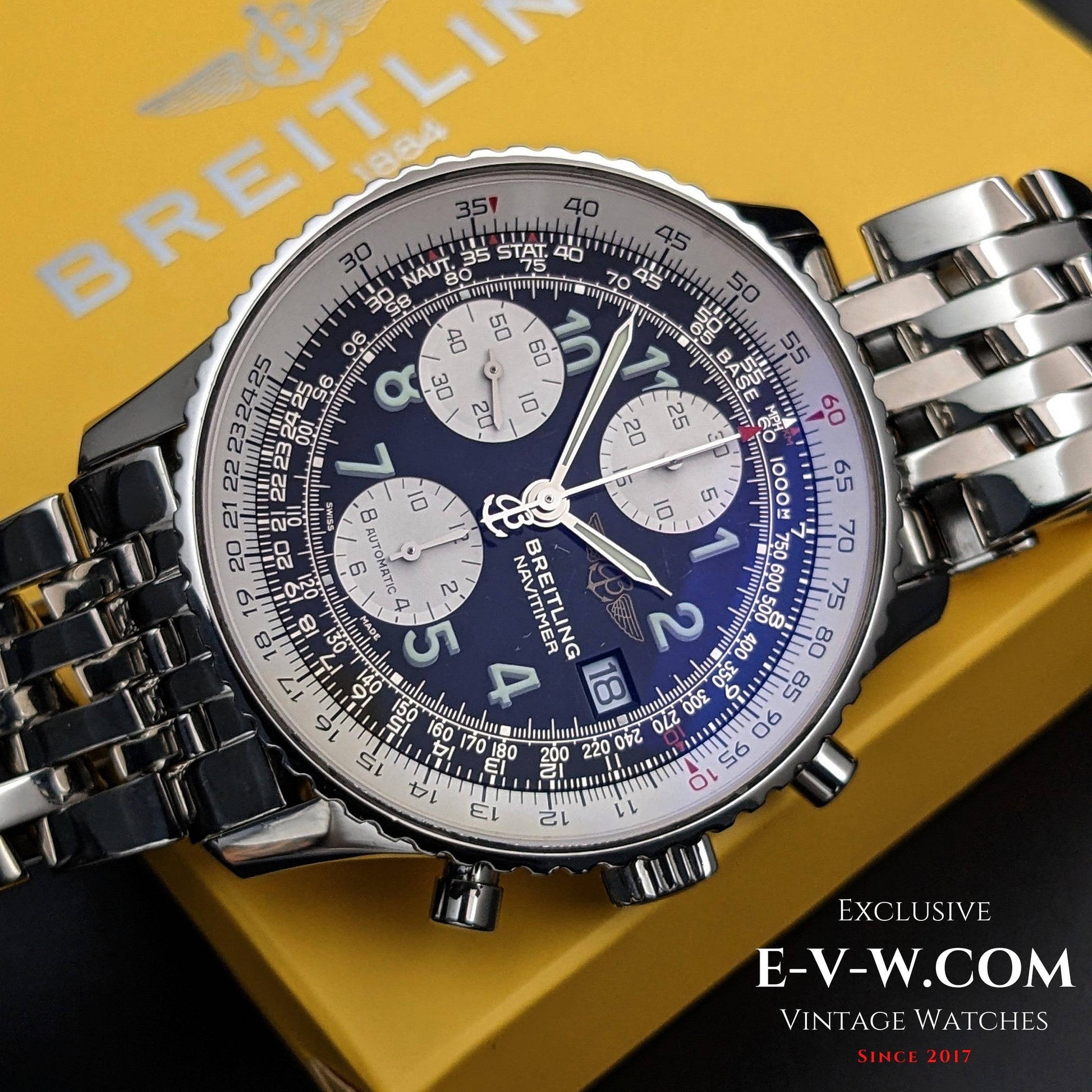 Breitling watch with detailed face on a yellow Breitling box background