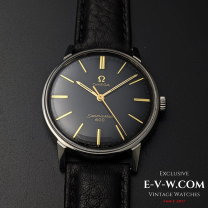 Front-facing view of Vintage Omega Seamaster 600 1966 Ref. 135011 with black dial, gold markers, and black leather strap on dark surface.