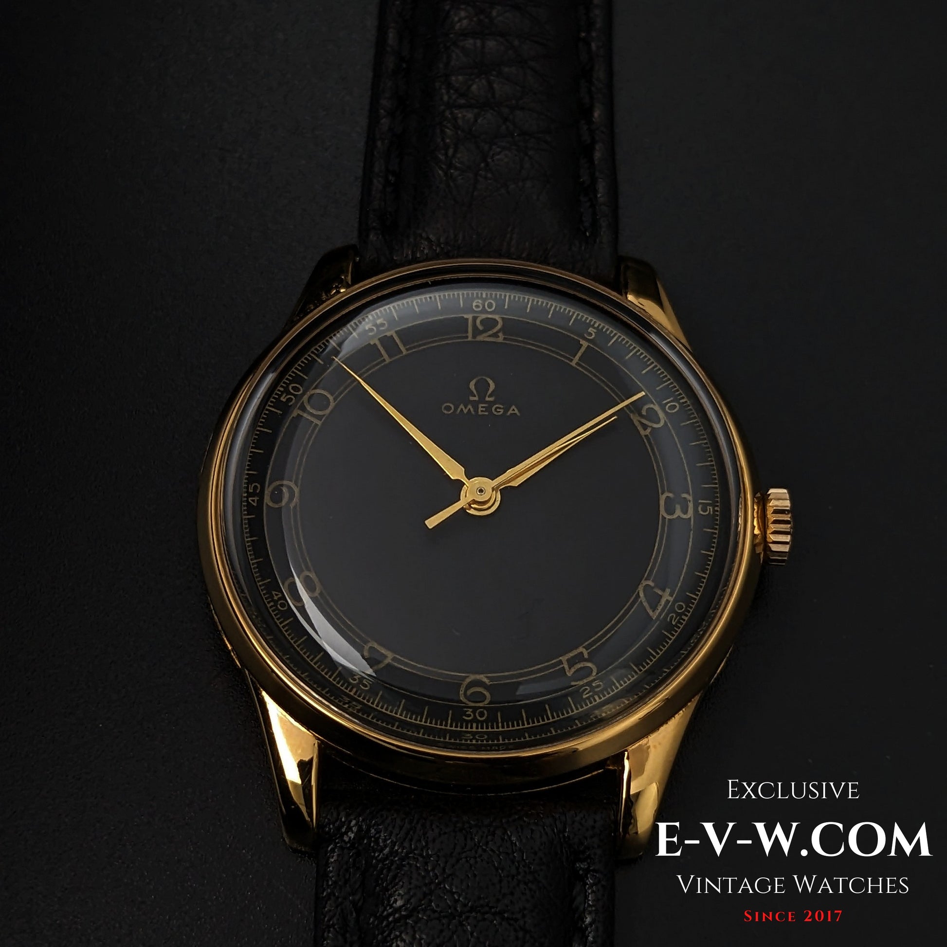 1944 Vintage Omega WWII Gold Watch with black and gold dial, shown on black leather strap, a timeless piece for vintage watch lovers.