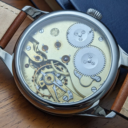Mechanical watch with visible gears on a wooden surface